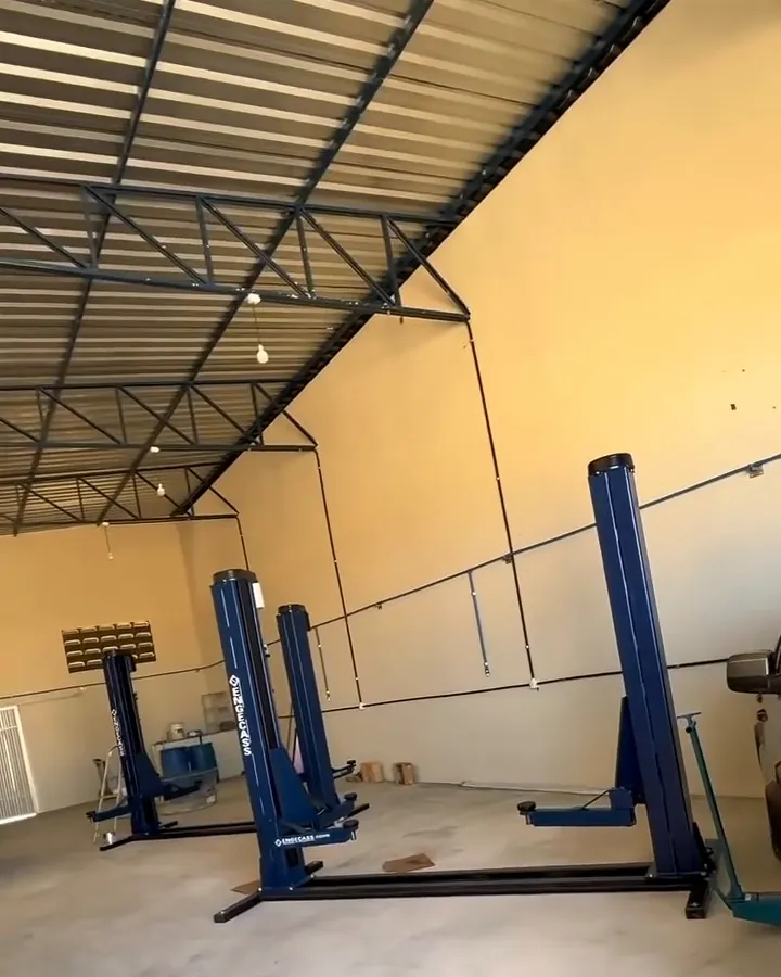 Galpão da oficina com elevadores automotivos e iluminação natural