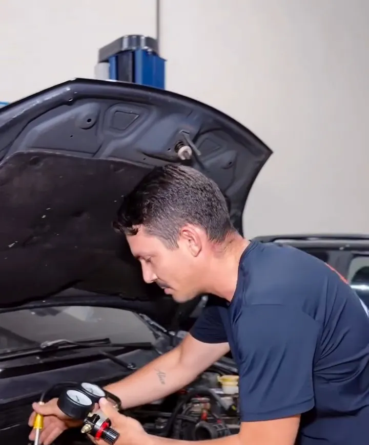 Mecânico trabalhando no motor com uma ferramenta de medição