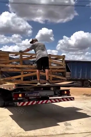 Caminhão chegando com equipamentos novos embalados em caixas de madeira