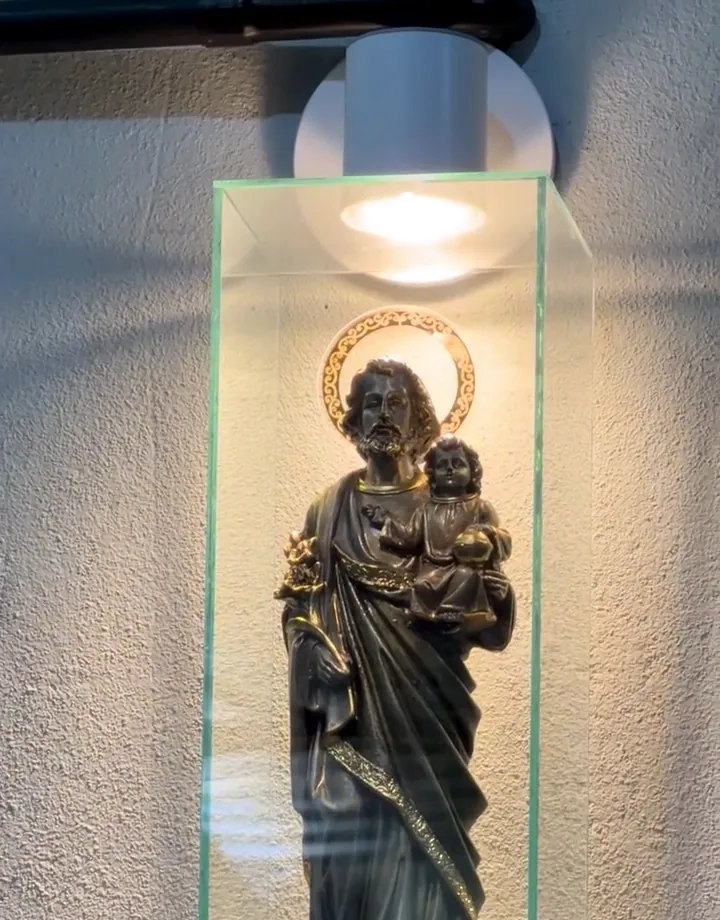 Imagem de São José iluminada em um nicho de vidro dentro da oficina