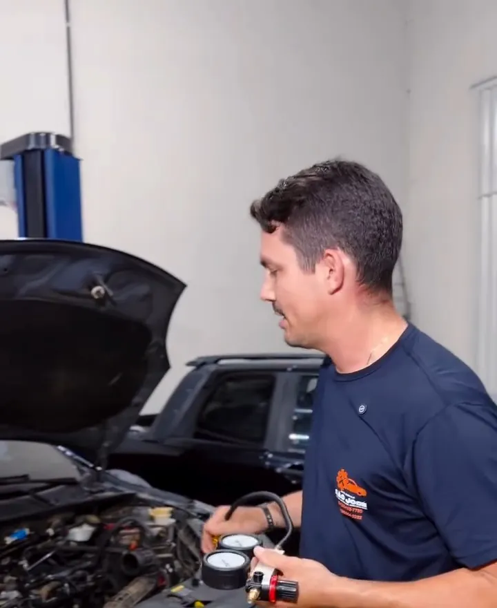 Mecânico examinando o motor de um carro com o capô aberto